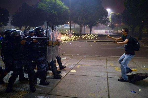 2. Brezilyalı bir protestocu yolsuzluk ve polis şiddetine karşı yapılan protestolar sırasında polislere engel olmaya çalışıyor.