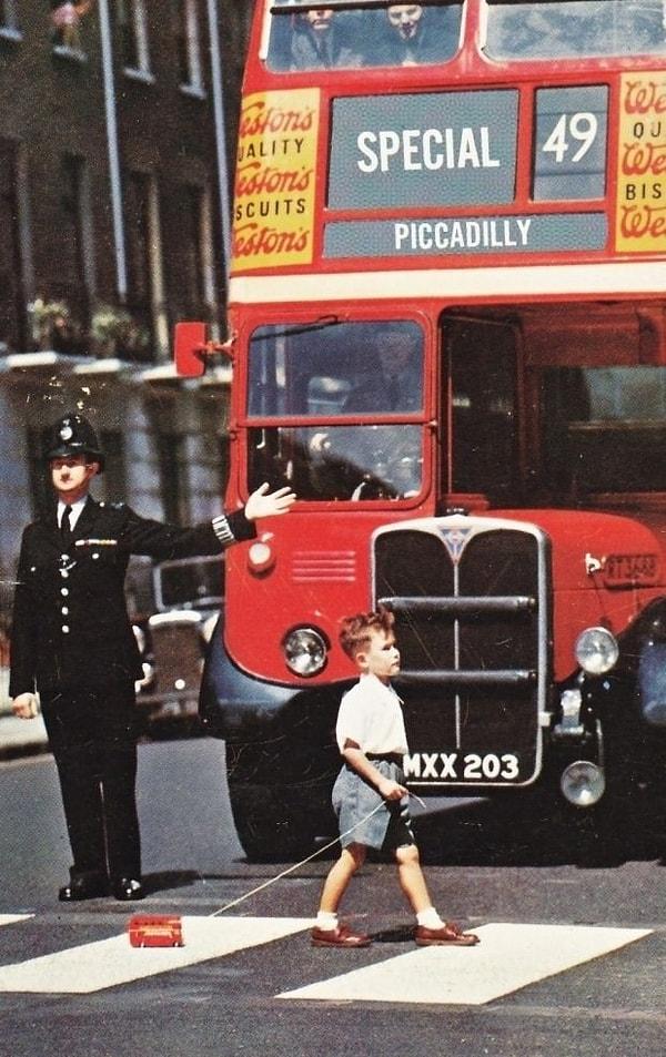 15. 1960'lı yıllarda bir çocuk oyuncak otobüsüyle Londra caddelerinde dolaşıyor.
