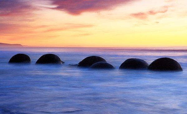 10. Yeni Zelanda'daki yuvarlak kayalar: Çamurtaşını çevreleyen kıyı erozyonu sonucu denizin içinde ve sahilde oluşan yuvarlak kayalar.
