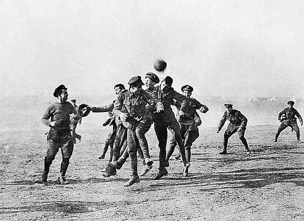 15. Siperlerinden çıkan İngiliz ve Alman askerleri futbol oynuyor (I. Dünya Savaşı, 1914)