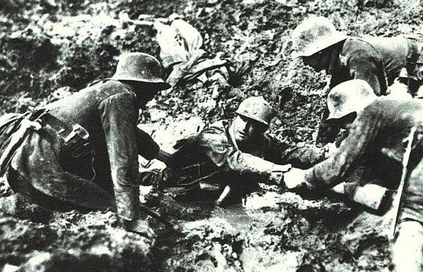 19. Üç Alman askeri bataklığa saplanmış olan Fransız askerine yardım ediyor (I. Dünya Savaşı, 1916)