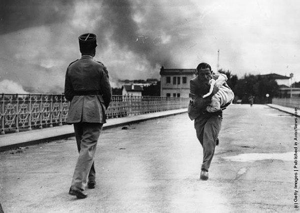 20. Gazeteci Raymond Walker İspanya İç Savaşı'ndan kaçırdığı çocuğu kucağına almış köprünün Fransız tarafına doğru kaçmaya çalışıyor.