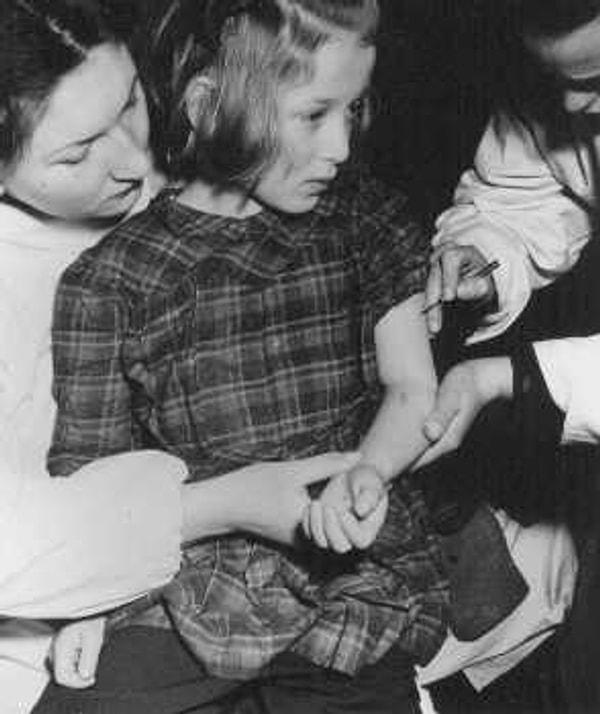 13. Birleşmiş Milletler personeli Auschwitz kampındaki tıbbî deneylerde kullanılan 11 yaşındaki sağ kalan çocuğa aşı yapıyor.