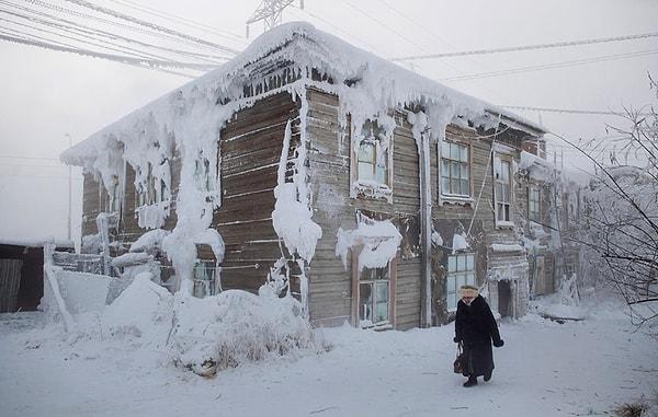 8. Kasaba merkezinde donmuş bir ev ve yürümeye çalışan bir kadın.