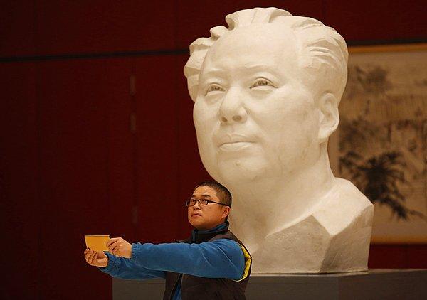 13. Çinli bir genç, Çin Halk Cumhuriyeti'nin kurucu önderlerinden Mao Zedong'un heykelinin önünde selfie çekerken.