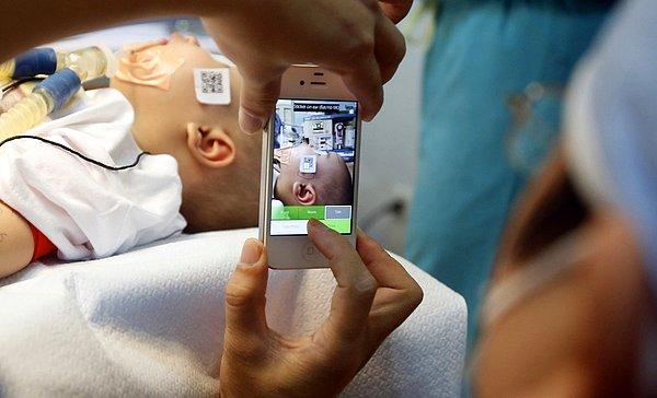 21. Vietnam'da bir doktor, ameliyata girmeden önce yüzünde şekil bozukluğu olan bir çocuğun fotoğrafını çekiyor.