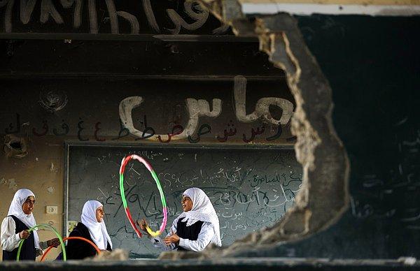 11. Gazze Şucaiyye'de 50 gün süren İsrail'le Hamas arasındaki çatışmada yıkılan okulları içinde oyun oynayan Filistinli kız çocukları, 5 Kasım 2014.