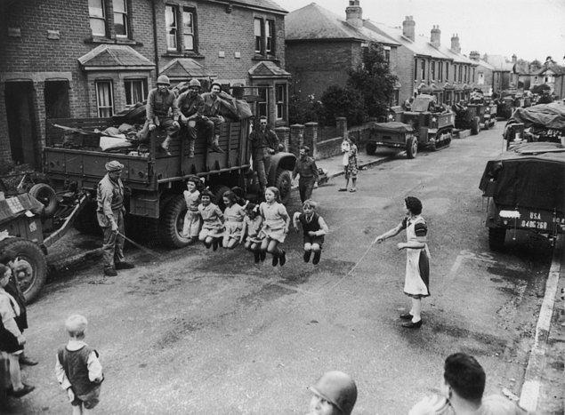 14. İp atlayan çocuklara yardım eden Amerikan askerleri, İngiltere, 1944.