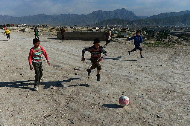 17. Kabil'de mezarlığa yakın bir tepede futbol oynayan Afgan çocuklar, 12 Nisan 2014.