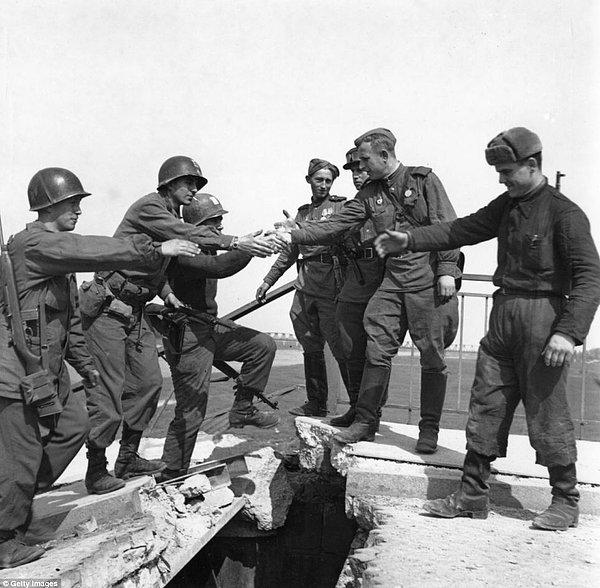 16. 2. Dünya Savaşı sırasında Amerikan askerleri yıkık bir köprü üzerinde Sovyet askerleri ile el sıkışıyor, 27 Nisan 1945
