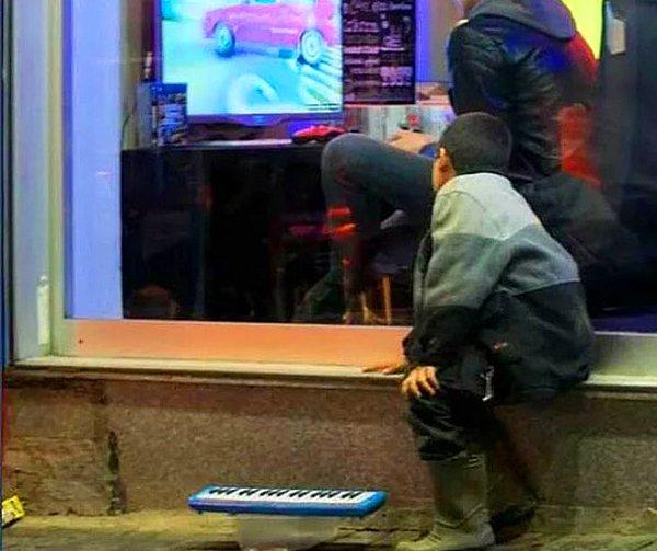 12. Soğukta dışarda oyun oynayanları izleyen çocuk