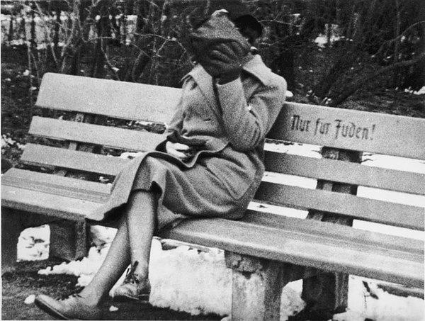 28. Almanya'da bir parkta "Sadece Yahudiler için" yazan bankta Yahudi bir kadın fotoğrafı çekilirken yüzünü gizliyor, 1938