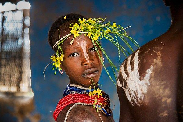 8. Çiçeklerle süslenmiş Etiyopyalı bir çocuk.