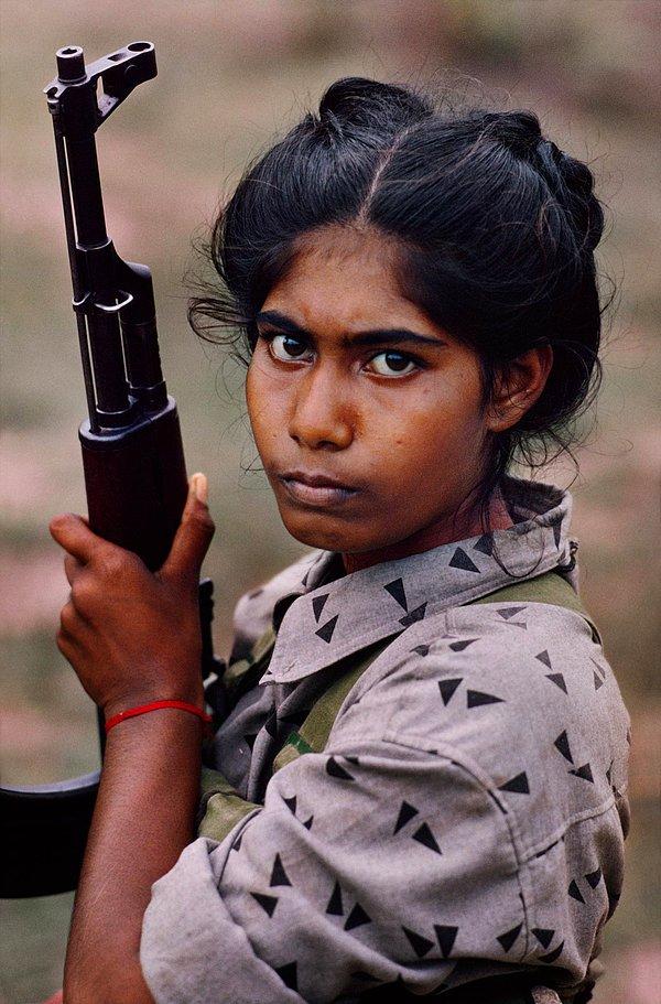 16. Silah kuşanmış Sri Lankalı bir kız çocuğu.