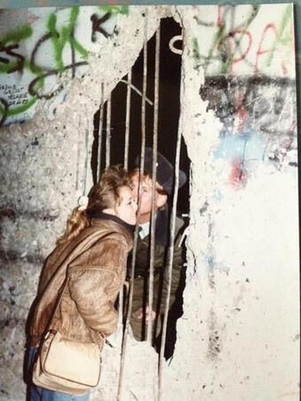 1. Berlin Duvarı daha yıkılmadığı zamanlarda bir çift gizlice öpüşürken.