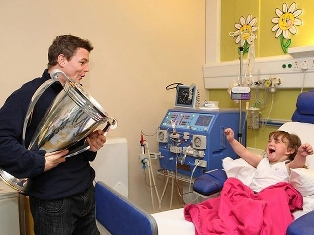 Kupa sevincini hastanedeki bir hayranı ile kutlayan İrlandalı rugby oyuncusu Brian O’Driscoll.