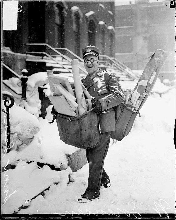 14. Amerikalı bir postacı Chicago'da yaptığı ağır Noel teslimatları ile birlikte poz verirken, 1929.