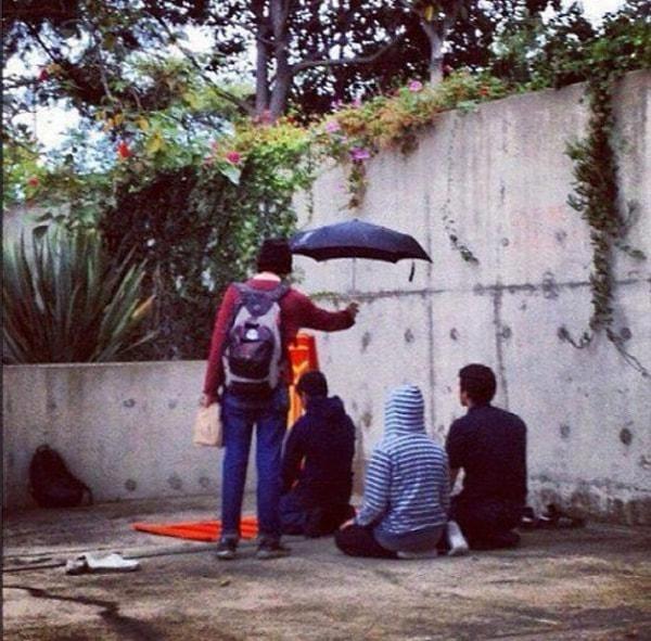 15. California Üniversitesinde namaz kılan Müslüman öğrencilere bir Hristiyan öğrenci şemsiye tutuyor.