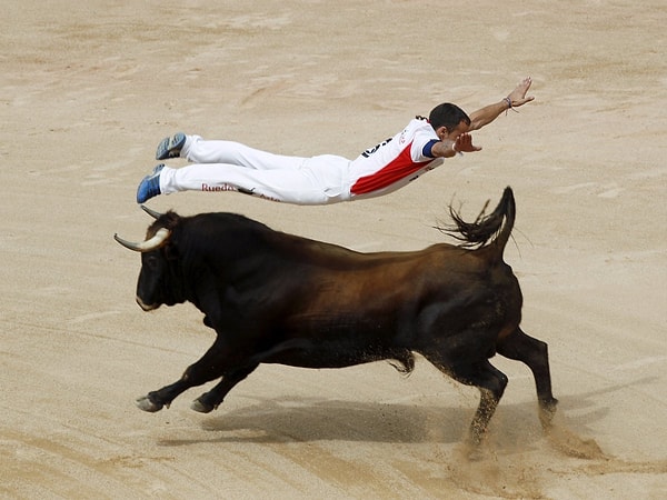 13. Тореадор перепрыгивает через быка во время соревнований на 6-ой день фестиваля «Сен-Фермин». Памплона, север Испании, 11 июля, 2015 г.
