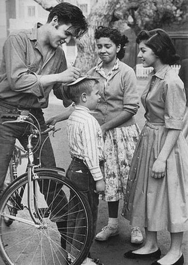 16. Elvis Presley imza verirken.
