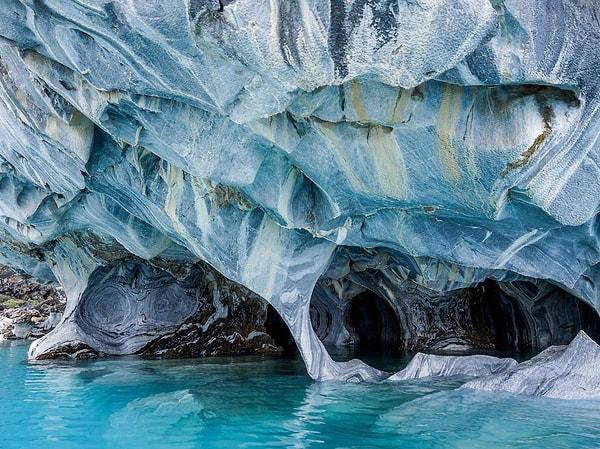 22. Şili'deki General Carrera Gölü'ne kıyısı olan bir yarımadada bulunan Mermer Mağaralar'ın duvarlarındaki desenler, dalgaların binlerce yıl boyunca kalsiyum karbonatı yıkamasıyla oluşmuş.