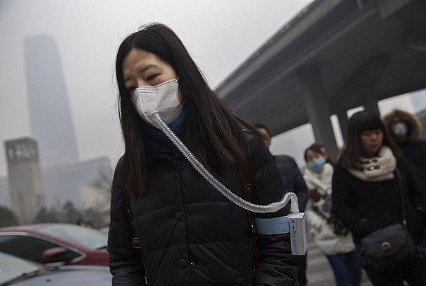 22. Pekin'deki yoğun hava kirliliği sırasında maske takmış olan Çinli bir kadın. 9 Aralık 2015.