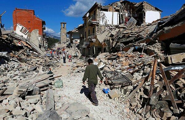 15. Pescara del Tronto'da depremin hemen ardından, bir adam enkazın arasında yürüyor.