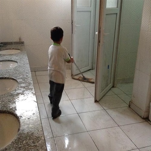 Fotoğrafta okulun tuvaletinde ilkokul öğrencisi bir erkek çocuğunun yerleri temizlediği görülüyor...