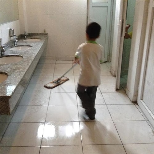 Fotoğrafta okulun tuvaletinde ilkokul öğrencisi bir erkek çocuğunun yerleri temizlediği görülüyor...