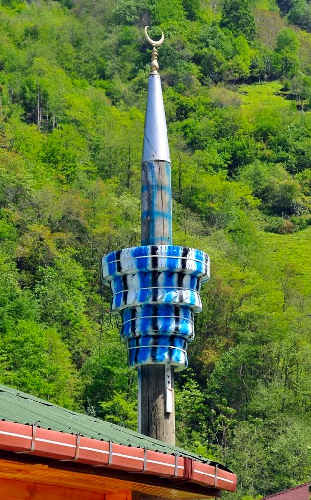 Elektrik direğine geçirilen boyalı lastiklerle yapılmış "kendin yap" modeli bir minare ?