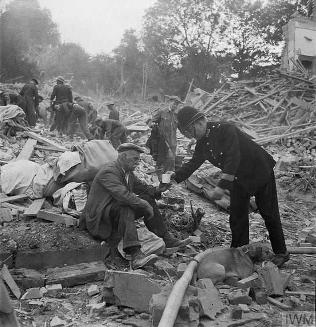 6. PC Frederick Godwin offers tea and sympathy to a now homeless man, who returned home from walking his dog to find his house destroyed and wife killed by a V1 flying bomb.