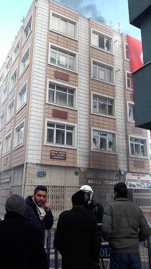Binanın camları taşlanırken çatıya çıkan grup bayrak astı