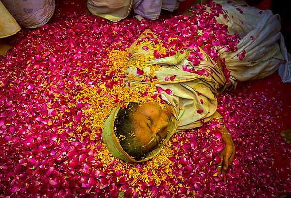 11. Yeni Delhi kentinin güneyinde Gopinath Tapınağı'nda Hindu dinine mensup bir Hintli dul kadın çiçek yaprakları üzerinde uzanmış.
