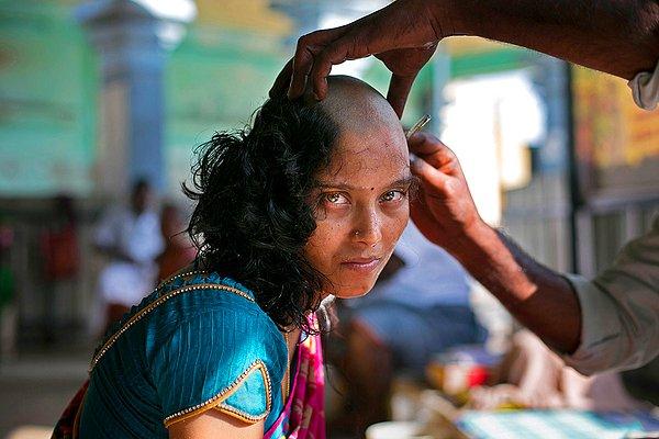 13. 28 yaşındaki Rupa, Thiruthani Murugan tapınağında tanrılardan kızının hastalığına çare olmasını istediği için saçlarını bağışlıyor.