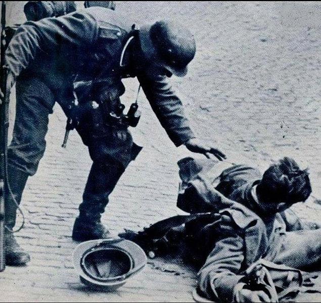 15. A German soldier trying to help the French soldier he shot a few seconds before the Battle of France - June 1940.