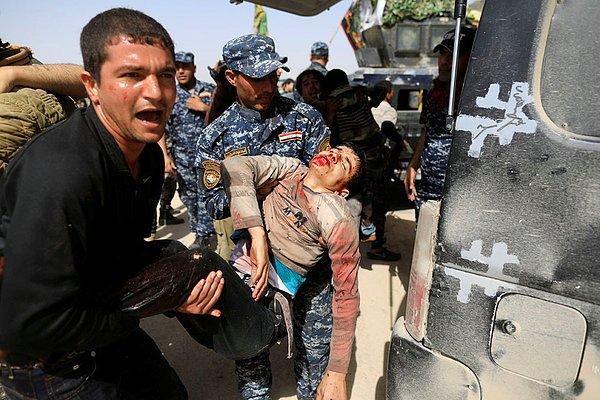 9. Iraklı federal güçler Tayaran bölgesinde bir dükkana yapılan bombalama sonucu yaralanan sivili taşıyor.