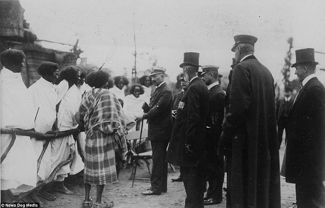 Alman Kaiser Wilhelm, Hamburg'da bir çitin arkasında tutulan Etiyopyalılar'la tanışıyor. Takvim 1909'u gösteriyor.