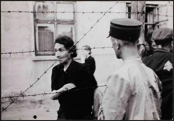 1942, Yahudi mahallesinde dikenli tellerin arkasında bir kadın ve polis