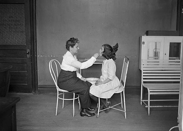 12. A girl undergoes a medical examination at the Bureau of Child Services in order to obtain a work certificate, circa 1915.