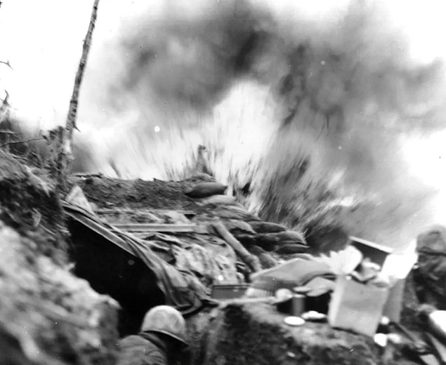 7. Marines duck for cover as a shell explodes near their position in 1952.