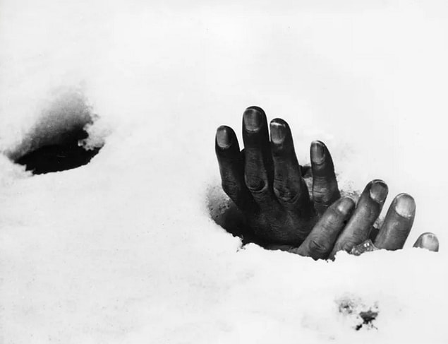 10. The bound hands of a dead Korean civilian, who was killed by retreating North Korean troops in 1951, stick out from the snow.