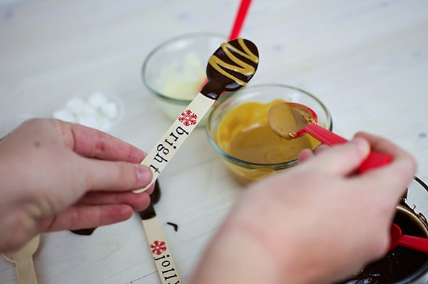 3. Далее окунаем ложку в темный или молочный шоколад и украшаем белым шоколадом или сгущенкой.