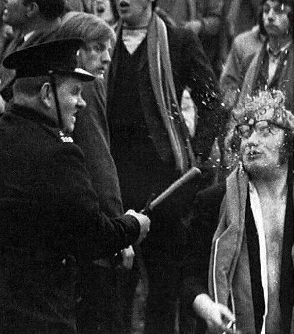 22. Polisin elindeki cop ile grev yapanlardan birinin gözlüklerini parçaladığı an, 1960'lar.