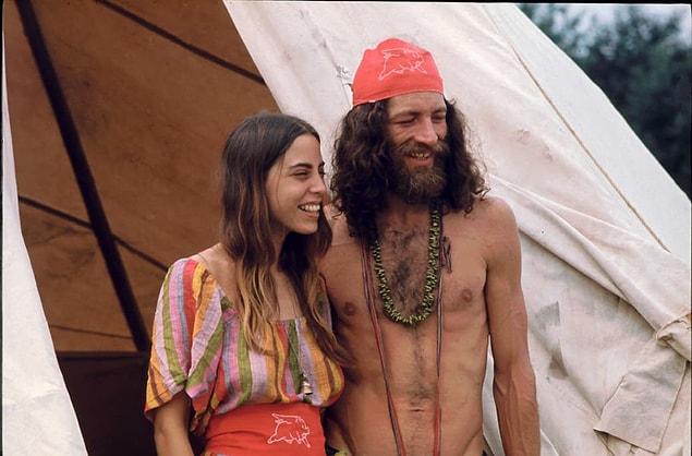 10. A couple attending the Woodstock Music and Arts Fair smile while standing outside the shelter they built.