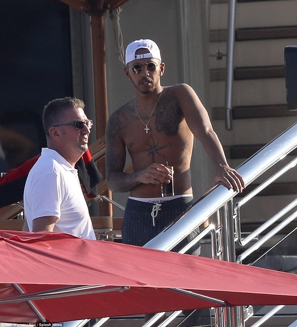 6. Хэмилтон в свою очередь разделся до пояса, демонстрируя свою коллекцию татуировок, не позабыв защитить голову от солнца с помощью белой кепки.