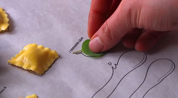 Раскладываем равиоли и листочек орегано…