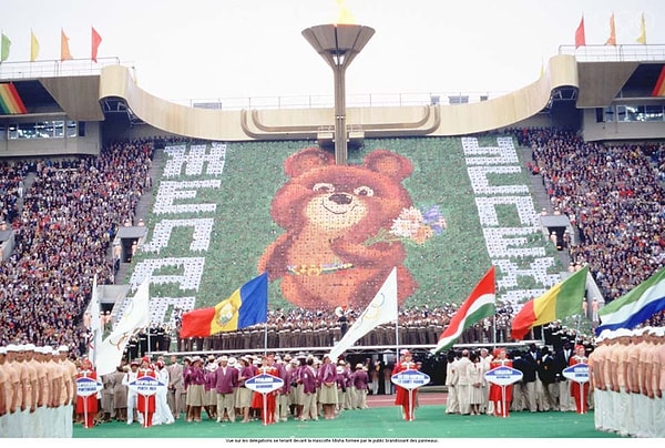7. Делегации на фоне олимпийского Мишки, составленного из разноцветных дощечек, которые держат зрители.