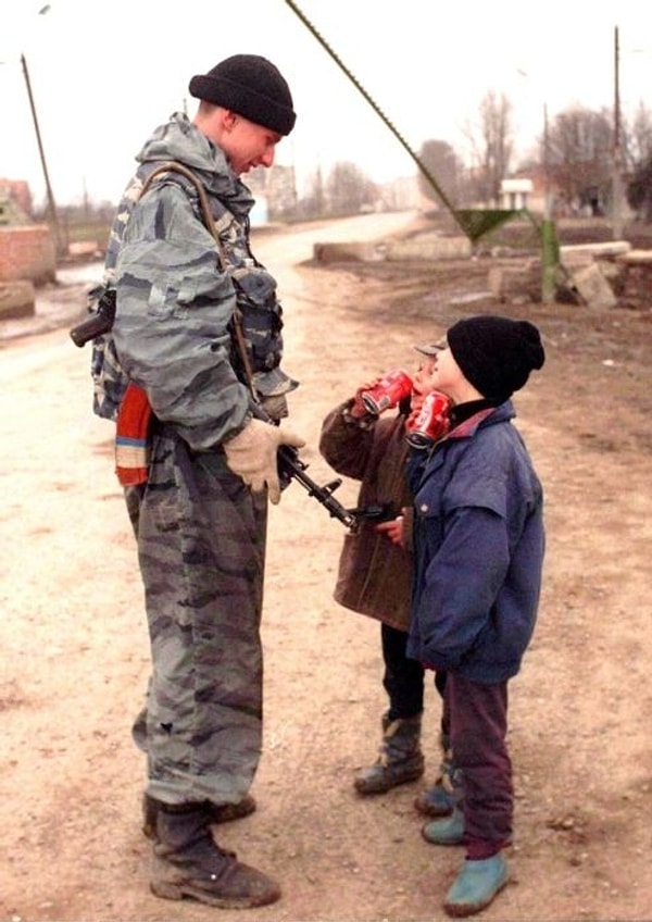 18. Русский командир разговаривает с чеченскими детьми, пьющими газировку, г. Грозный