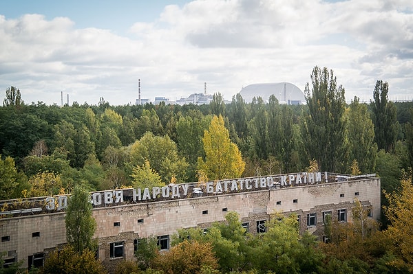 11. "Здоровье народа - богатство страны", - именно это гласит надпись на медсанчасти №126, куда после взрыва доставляли первых пострадавших - пожарных, которые тушили огонь. В подвале здания до сих пор лежит радиоактивная одежда и личные вещи ликвидаторов. Позади медсанчасти виднеется тот самый 4-ый энергоблок.