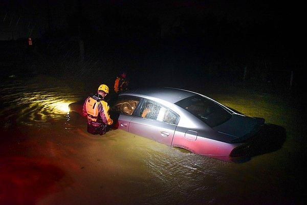 11. Porto Riko'da belediyenin acil durum ekipleri kasırgada sular altında kalmış bir aracın içini inceliyor.
